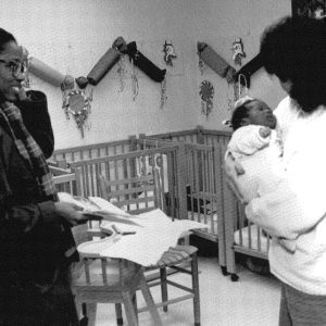 Black and white photo of teacher holding baby almost 35 years ago