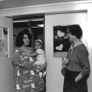 black and white photo of staff holding a child while talking almost 35 years ago